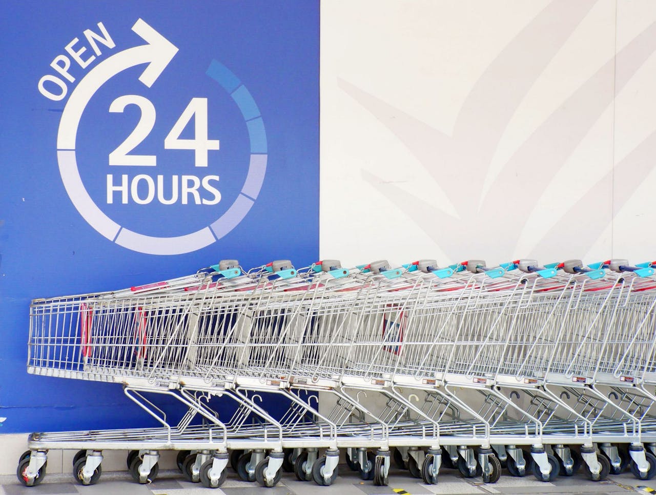 Row of shopping trolleys outside a 24-hour supermarket in Singapore, emphasizing convenience and accessibility.